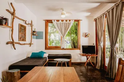 a room with a bed and a table and a window at Griss Lodge & Spa in Santa Teresa Beach