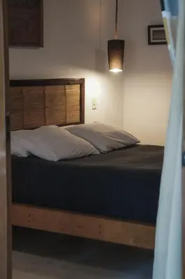 a bedroom with a bed with a wooden headboard at Griss Lodge & Spa in Santa Teresa Beach