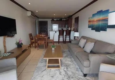 a living room with a couch and a table at Sunset Heights 402 in Playa Flamingo
