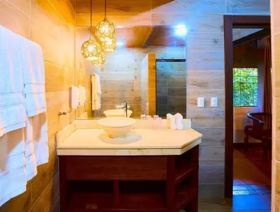 a bathroom with a sink and a mirror at Aninga Lodge in Tortuguero