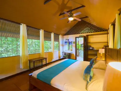 a bedroom with a large bed with a ceiling fan at Aninga Lodge in Tortuguero