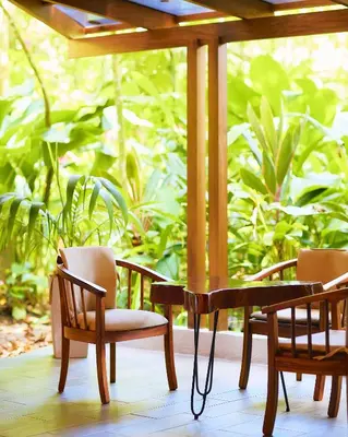 two chairs and a table on a porch at Aninga Lodge in Tortuguero