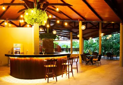 a bar in a restaurant with tables and chairs at Aninga Lodge in Tortuguero