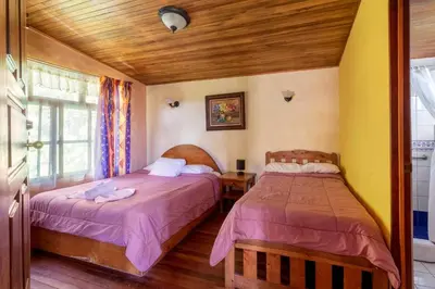 a bedroom with two beds and a window at Hotel Claro de Luna in Monteverde Costa Rica