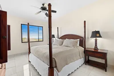 a bedroom with a bed and a ceiling fan at Recently Renovated Luxury Condo with Resort-Style Beach Club Access and Ocean Views in Playa Conchal