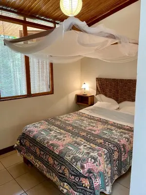 a bedroom with a bed with a canopy at Finca Isla Rainforest Retreat in Aguas Zarcas