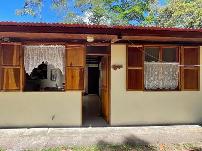 a small house with a door and a window at Finca Isla Rainforest Retreat in Aguas Zarcas
