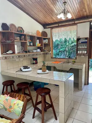 a kitchen with a large counter with stools in it at Finca Isla Rainforest Retreat in Aguas Zarcas