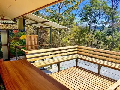a wooden bench sitting on top of a porch at Santa Teresa Surf Vista Villas in Santa Teresa Beach