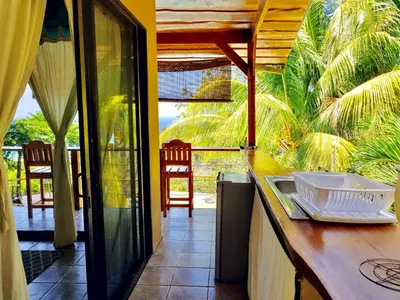 a kitchen with a counter with a view of a patio at Santa Teresa Surf Vista Villas in Santa Teresa Beach