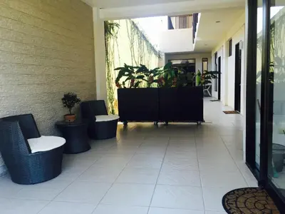 a hallway with chairs and plants in a building at Cabinas Gosen in Puntarenas