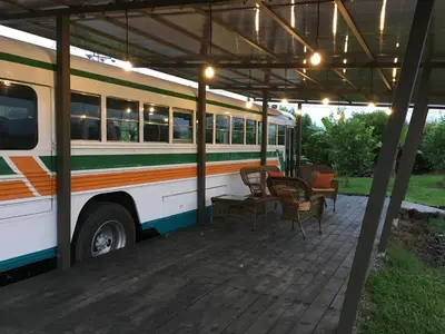 a bus parked under a roof with tables and chairs at Posada Cañaveral in Ujarrás