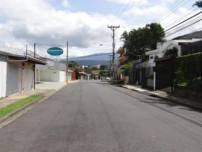 an empty street in a town with a sign at Maria´s Apartments in Alajuela City