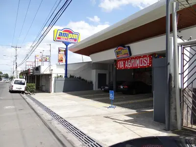 a fast food restaurant with a sign for a car dealership at Maria´s Apartments in Alajuela City