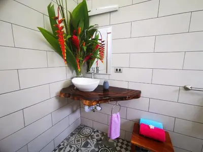 a bathroom with a sink and a mirror at Agutipaca Bungalows in Bagaces