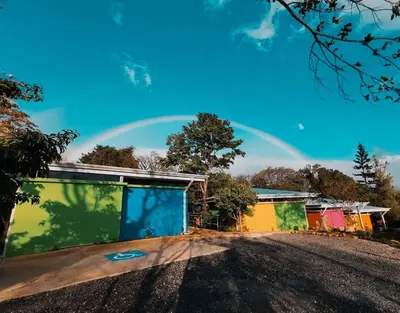 a rainbow in the sky above a building at Agutipaca Bungalows in Bagaces