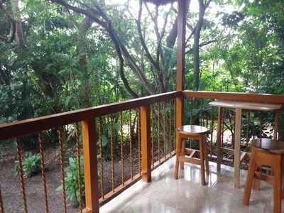 a balcony with a table and two stools at Rancho de Lelo Ecolodge in Monteverde Costa Rica