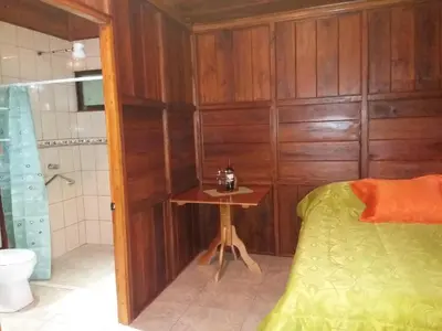 a bathroom with a bed and a shower and a table at Rancho de Lelo Ecolodge in Monteverde Costa Rica