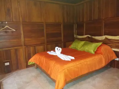 a bedroom with a bed with a white bow on it at Rancho de Lelo Ecolodge in Monteverde Costa Rica