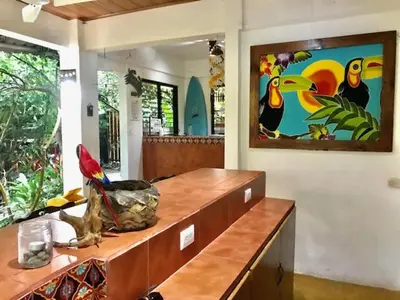 a room with a counter with a painting on the wall at Hotel Tropical Sands Dominical in Dominical