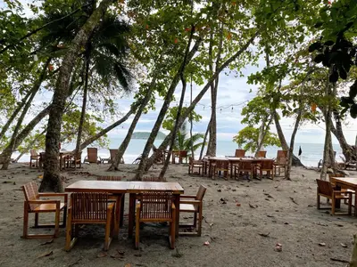 a group of tables and chairs on a beach at Arenas Del Mar Beachfront & Rainforest Resort Member of the Cayuga Collection in Manuel Antonio
