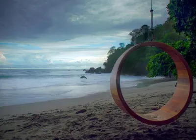 a mirror on a beach with the ocean at Arenas Del Mar Beachfront & Rainforest Resort Member of the Cayuga Collection in Manuel Antonio