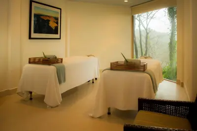 a room with two tables and a window at Arenas Del Mar Beachfront & Rainforest Resort Member of the Cayuga Collection in Manuel Antonio