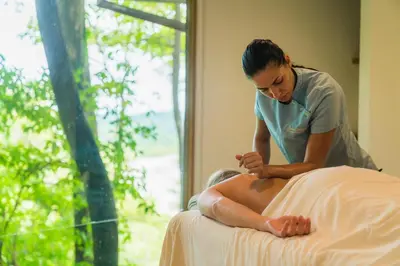 a woman sitting on top of a bed at Arenas Del Mar Beachfront & Rainforest Resort Member of the Cayuga Collection in Manuel Antonio