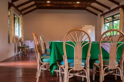 a dining room with a green table and chairs at Hotel Villa Zurqui in San José