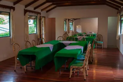 a group of green tables and chairs in a room at Hotel Villa Zurqui in San José