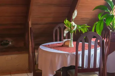 a table with two chairs and a vase on it at Hotel Villa Zurqui in San José