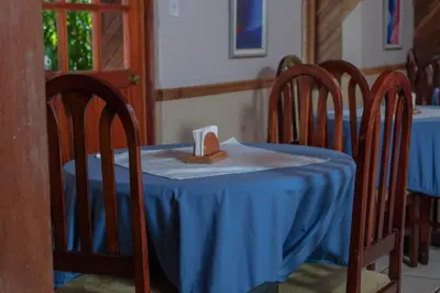 a table with a blue table cloth and three chairs at Hotel Villa Zurqui in San José