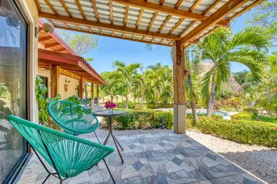 a patio with chairs and a table and a pergola at Hotel Villas Tangerine in Sámara