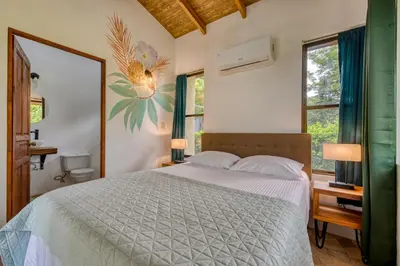 a bedroom with a bed and two windows at Hotel Villas Tangerine in Sámara