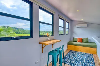 a room with a bed and a desk and two chairs at Hotel Villas Tangerine in Sámara