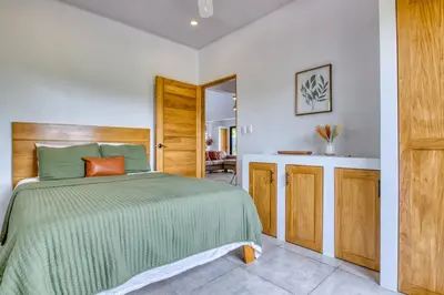 a bedroom with a bed with a green bedspread at Hotel Villas Tangerine in Sámara