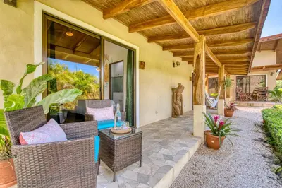 an outdoor patio with wicker chairs and a table at Hotel Villas Tangerine in Sámara
