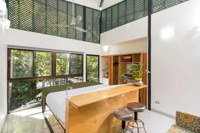 a bedroom with a bed and a desk with stools at Yaba Chigui Lodge in Ojochal