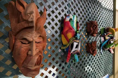 a wall with wooden masks and shoes hanging on it at Yaba Chigui Lodge in Ojochal