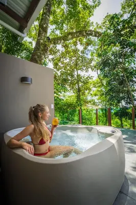 a woman sitting in a bath tub with a flower at Chira Glamping Resort Monteverde in Monteverde Costa Rica