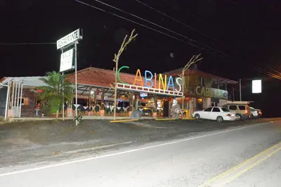 a store on the side of a street at night at Valle Encantado in San Isidro