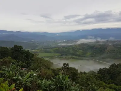 a view of a misty valley with a river and mountains at Valle Encantado in San Isidro