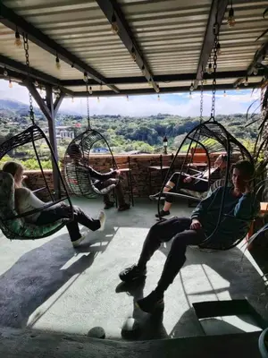 a group of people sitting in swings on a porch at Cabinas Vista Al Golffo in Monteverde Costa Rica
