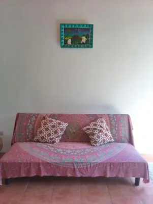 a purple couch with pillows on it in a room at Blanconejo de Montezuma in Montezuma