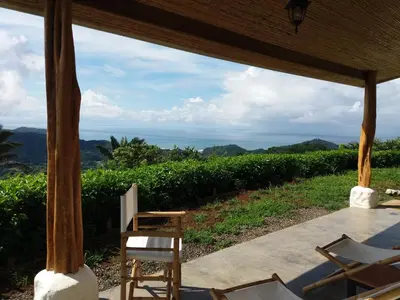 a porch with chairs and a view of the ocean at Hotel Peace & Lodge in Sámara