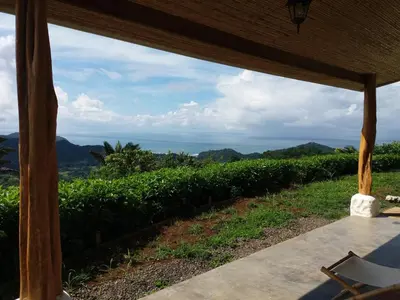 a view of the ocean from the porch of a house at Hotel Peace & Lodge in Sámara