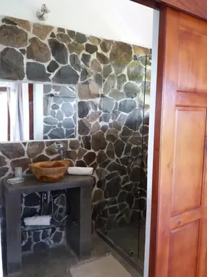 a stone bathroom with a sink and a shower at Hotel Peace & Lodge in Sámara