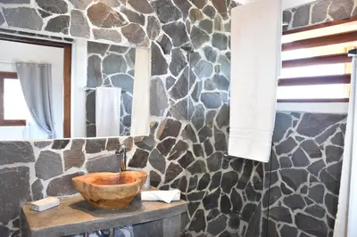 a bathroom with a wooden bowl on a wooden table with a mirror at Hotel Peace & Lodge in Sámara