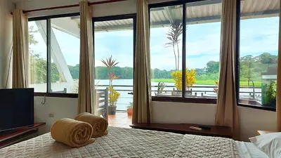 a bedroom with a bed with a view of the water at Tortuguero Adventures GuestHouse in Tortuguero