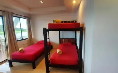 two bunk beds in a room with a window at Tortuguero Adventures GuestHouse in Tortuguero